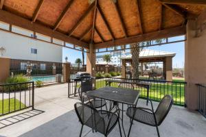 a patio with tables and chairs and a grill at Extended Stay America Suites - Houston - IAH Airport in Houston