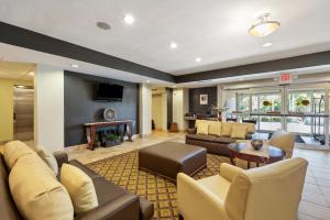 Extended Stay America Suites - Houston - IAH Airport في هيوستن: غرفة معيشة مع أريكة ومدفأة