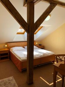 ein Schlafzimmer mit einem großen Bett im Dachgeschoss in der Unterkunft Brezina Pension in Prag