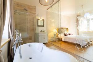 ein Badezimmer mit einer Badewanne und ein Schlafzimmer mit einem Bett in der Unterkunft Royal Jono st. Apartment in Klaipėda + 28 Fotos