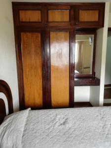 a bed with a wooden door and a mirror at Hotel La Joya in La Paz