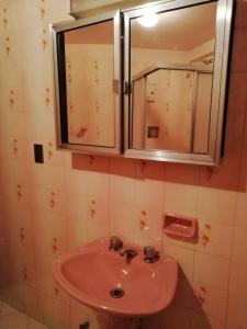 baño con lavabo rosa y espejo en Hotel La Joya, en La Paz