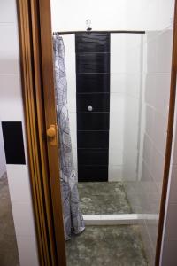 ein Bad mit einer Dusche und einer schwarzen Tür in der Unterkunft I Wanna Palomino in Palomino