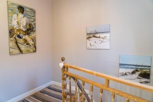 a staircase with three paintings on the wall at Ferienhaus am Fluss. Baubiologisch renoviert. in Bad Kreuznach
