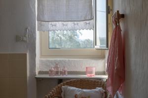 ein Fenster in einem Zimmer mit einem Korbstuhl und einem Fensterbrett in der Unterkunft Masseria Pugliese Farm in Ostuni
