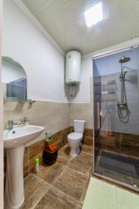 a bathroom with a toilet and a sink and a shower at TES Hotel in Osh