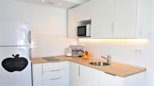 Biała kuchnia z lodówką i zlewem w obiekcie Casa La Moringa - Holiday house close to the beach w mieście Arguineguín +10 zdjęć