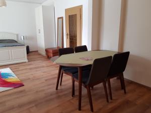 un tavolo da pranzo con sedie in una stanza con un letto di 70m² Zweiraumwohnung am Spreewaldradweg in Cottbus a Cottbus