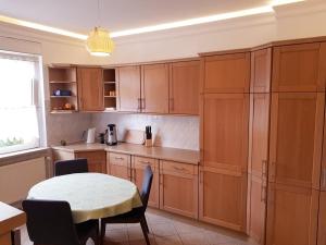 a kitchen with wooden cabinets and a table with chairs at 70m² Zweiraumwohnung am Spreewaldradweg in Cottbus in Cottbus