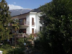 una casa bianca con balcone e montagne sullo sfondo di Oasi a Malcesine
