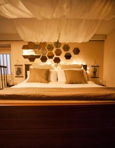 um quarto com uma cama grande com lençóis brancos e almofadas em Vanvitelli's Home em Caserta