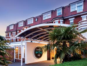a large red and white building with a balcony at Bournemouth West Cliff Hotel in Bournemouth