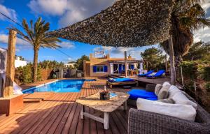 a villa with a swimming pool and a wooden deck at Casa Made in China in Es Pujols