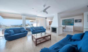 Una sala de estar con dos sofás azules y una mesa. en Villa Med, en Sitges