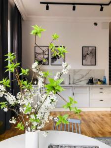 a kitchen with a table and a vase with flowers at Piper Park Wilsona & Targi in Poznań