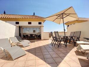 eine Terrasse mit einem Tisch, Stühlen und einem Sonnenschirm in der Unterkunft Ribera Beach 2 - 1509 in Mar de Cristal