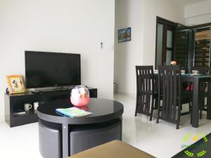 een woonkamer met een televisie en een tafel met stoelen bij °Garden Bay°country garden danga bay JOHOR in Johor Bahru