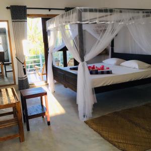 una camera con letto a baldacchino di Cili Hotel ad Arugam