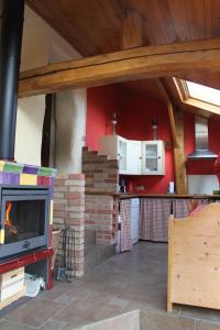 a living room with a fireplace and a kitchen at Le clos de Tournes in Echinghen