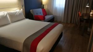a bed room with a white bedspread and a white comforter at Holiday Inn Express Málaga Airport, an IHG Hotel in Málaga