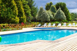 a swimming pool with lounge chairs and a volley ball at Hotel y Cabañas Molino Viejo in Puerto Varas