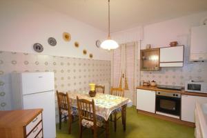 レヴァントにあるCasa vacanza Francescaのキッチン(テーブル、椅子、冷蔵庫付)