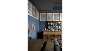 a dining room with a bar with blue walls at c-hotels Joy in Florence +35 photos