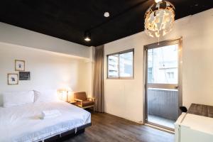 a bedroom with a bed and a window and a chandelier at Place Inn Taipei in Taipei