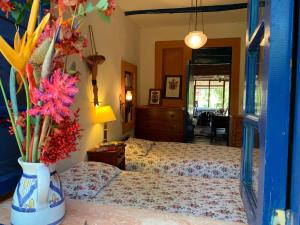 1 Schlafzimmer mit 2 Betten und einer Vase mit Blumen in der Unterkunft El Palacio in Choachí