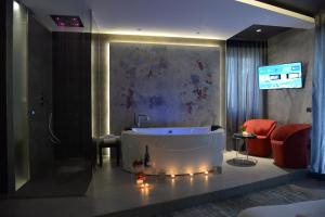 a bathroom with a tub and a tv in a room at suite28 in Brindisi