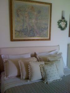 a bedroom with a painting above a bed with pillows at Nerantza Villa Jolimax in Nerátza +23 photos