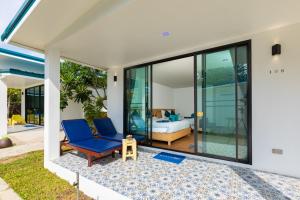 Zimmer mit einem Bett und einem blauen Stuhl auf einer Terrasse in der Unterkunft Paradise Resort Phi Phi-SHA Plus in Ko Phi Phi