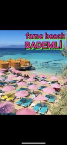een strand met roze parasols en de woorden fame beach badelin bij Gunes tatil köyü in Bademli