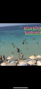 a group of people in the water at a beach at Gunes tatil köyü in Bademli