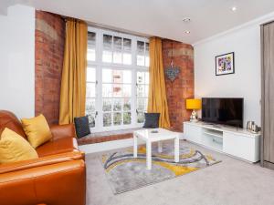 a living room with a couch and a tv at Cocoa Suites Luxury Apartments in York
