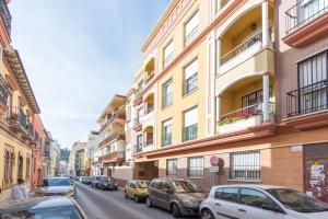 una calle con coches estacionados en el lateral de un edificio en Homemálaga Penthouse Victoria, en Málaga