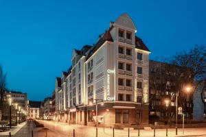a large white building on a city street at night at Q19 Apartments Old Town in Wrocław