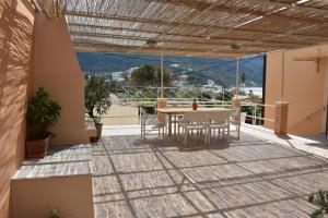 een patio met een tafel en stoelen op een balkon bij Patras Studio in Agios Georgios Pagon