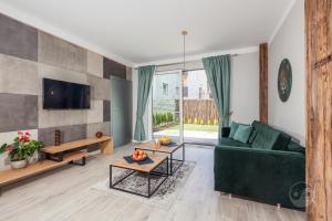 salon z zieloną kanapą i telewizorem w obiekcie Apartament Natura I we Władysławowie