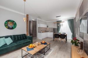 a living room with a green couch and a table at Apartament Natura I in Władysławowo