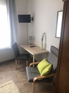 a living room with a table and a chair and a desk at Landgasthaus Jägerhof in Büren