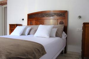 a bedroom with a large white bed with a wooden headboard at I Baronetti in centro in Agropoli