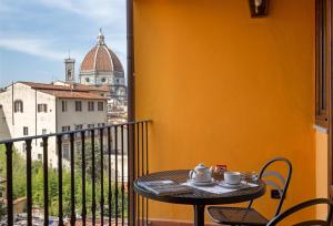 Palazzo Graziani في فلورنسا: طاولة وكراسي على شرفة مطلة على مدينة