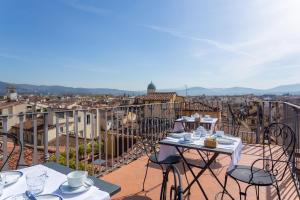 a balcony with tables and chairs and a view of a city at Palazzo Graziani in Florence