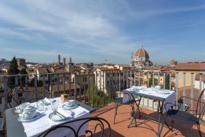 two tables and chairs on a balcony with a view of a city at Palazzo Graziani in Florence