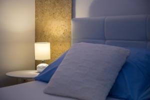 a bed with a blue comforter and a table with a lamp at Apartments Nada in Dubrovnik