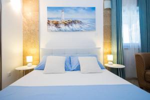 a bedroom with a white bed and a lighthouse at Apartments Nada in Dubrovnik