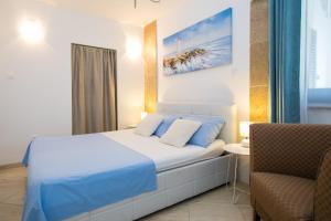 a hotel room with a bed and a chair at Apartments Nada in Dubrovnik