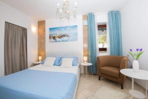 a hotel room with a bed and a chair at Apartments Nada in Dubrovnik