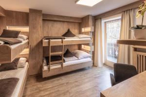 Pokój z 3 łóżkami piętrowymi i stołem w obiekcie XL Appartements Steinhaus w mieście Cadipietra